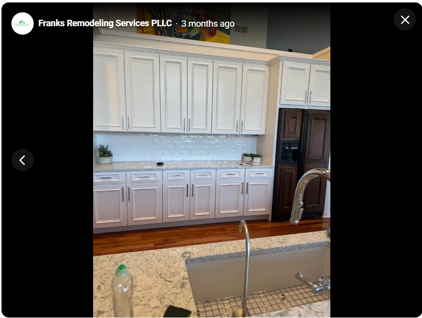White custom kitchen cabinetry with a light countertop and wood flooring
